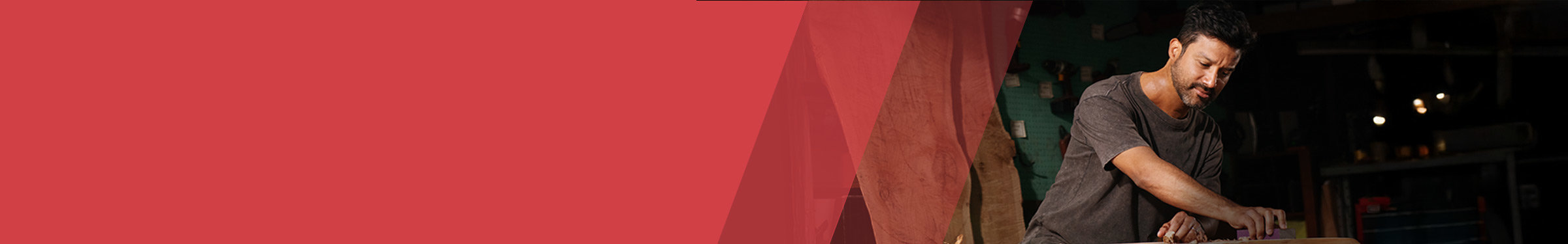 Red section header with a man to the right in a workshop sanding a surface on a table.