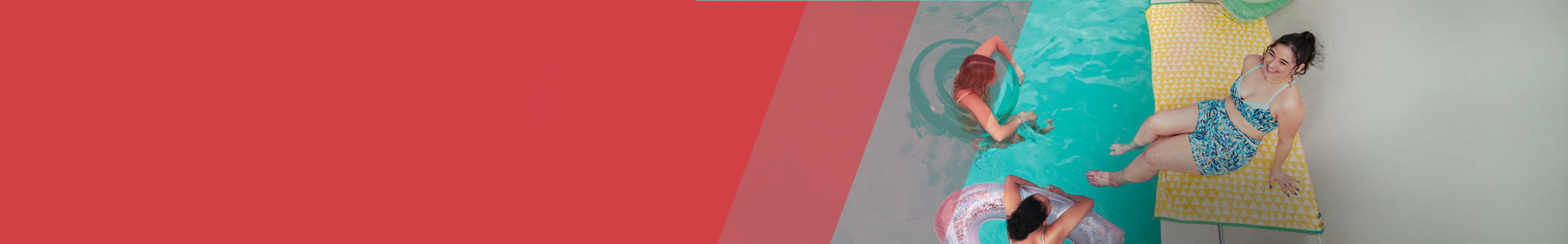 Woman in blue bathing suit sitting on a yellow towel with feet in the pool and two other women in round floats in the pool.